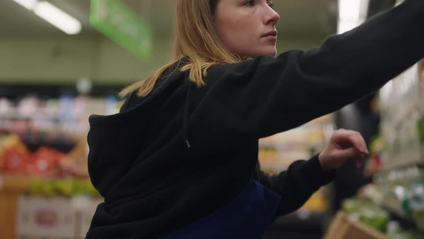 A woman in a grocery store searching the shelves