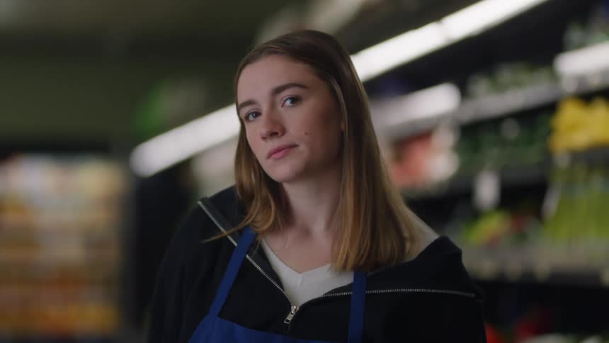 A store employee looks bored as she stands in an aisle