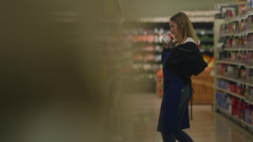 A worker is dancing in the aisle of the grocery store