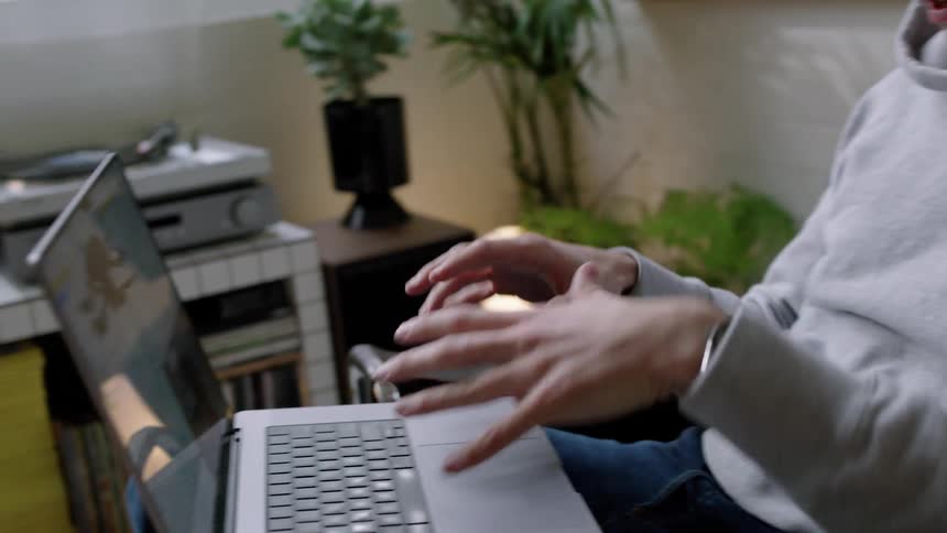 A man is talking to someone on a video call then typing