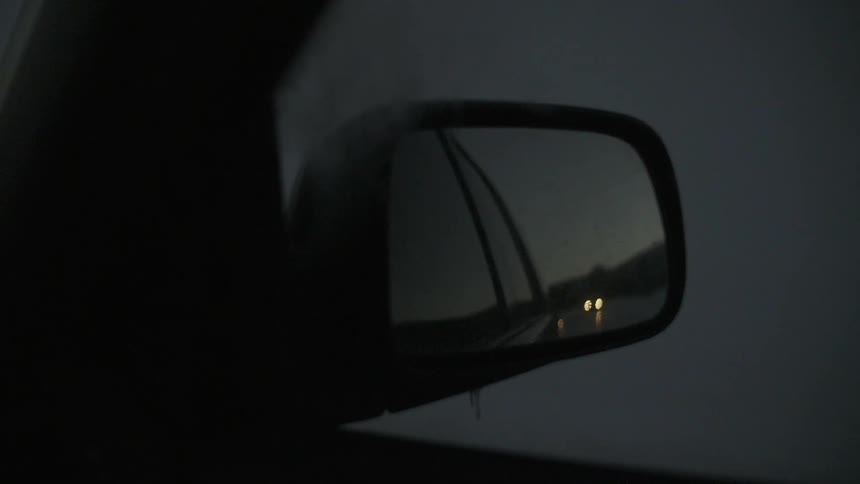 A car is following in rear view mirror display