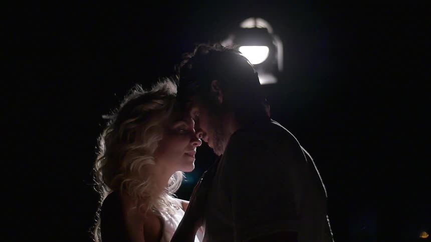 A woman is close to a man touching his head