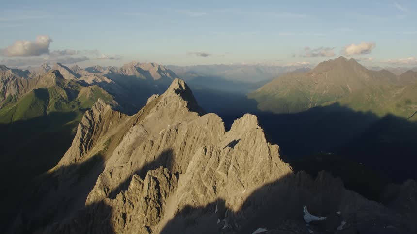 Aerial view of the jagged ridges of a mountain range summit at morning