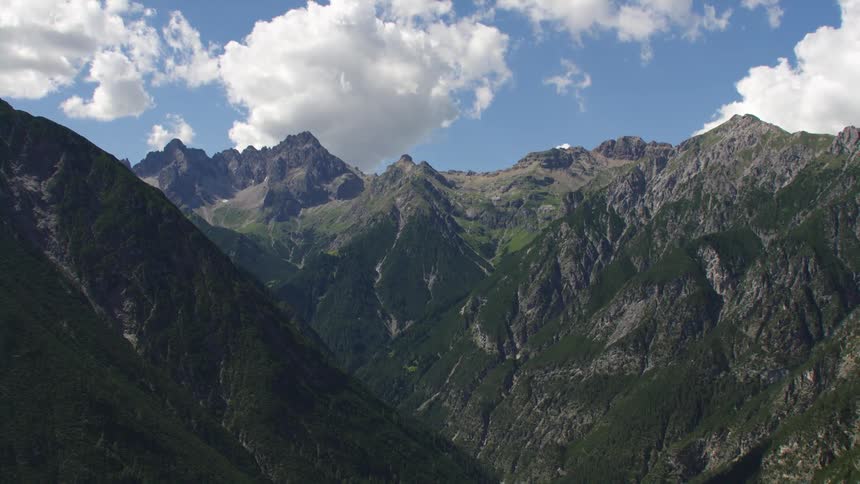 Forest covers side of mountains under a cloudy sky