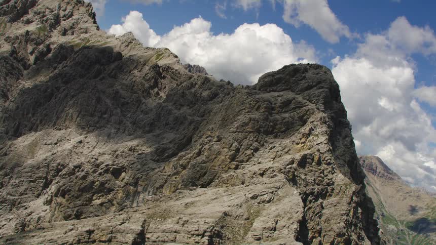 Craggy mountain bordering valley remains partially in shadow