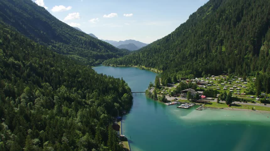 Aerial view of coastal town next to river and mountain forest