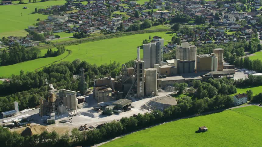 A large energy plant surrounded by green fields and village homes