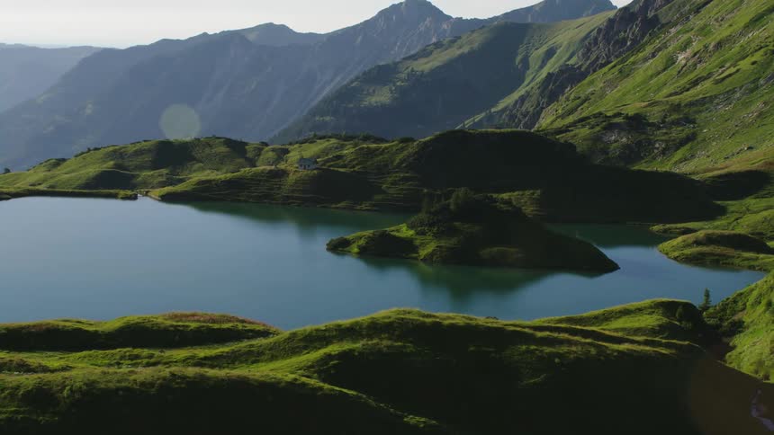 A small lake on a flat area on a mountain ridge during the day