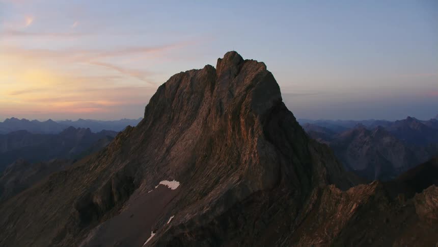 Aerial view of a cross atop the summit of a mountain range at morning