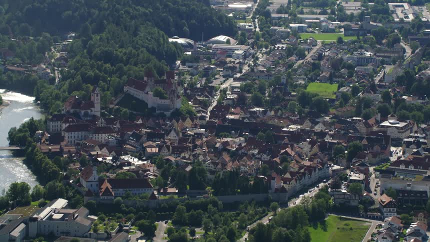 Aerial view of buildings next to forest and river in the city
