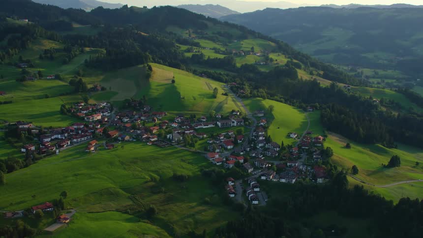 A small village is nestled high atop a beautiful hilly landscape