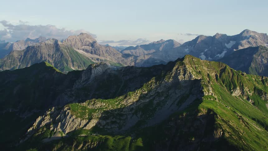 Aerial view of green lush vegetation on the slopes of a mountain range at morning