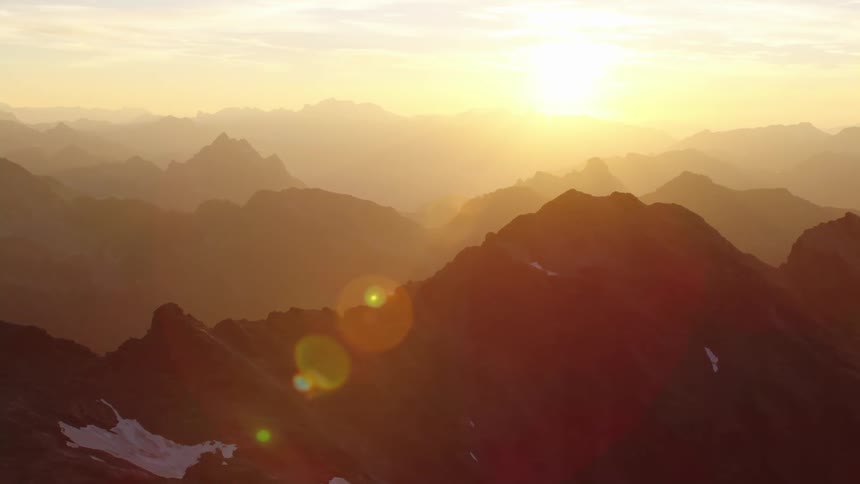 A rocky mountain range surrounded in fog in the evening