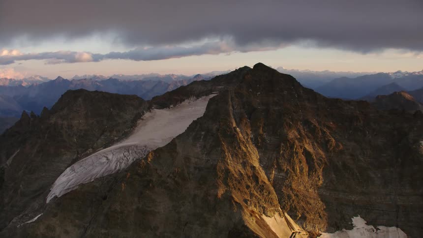 Aerial view of the snow covered slopes of a mountain range at morning