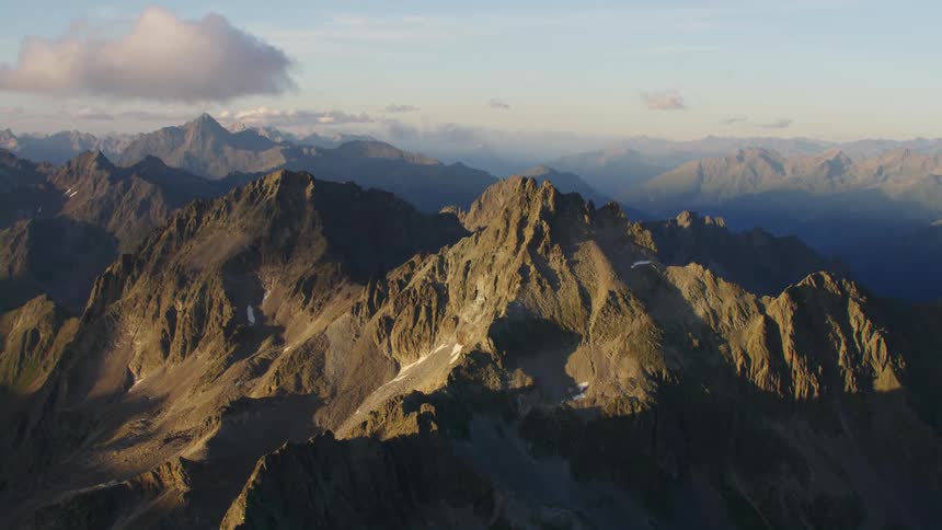 An enormous mountain range can be seen from high in the sky above it