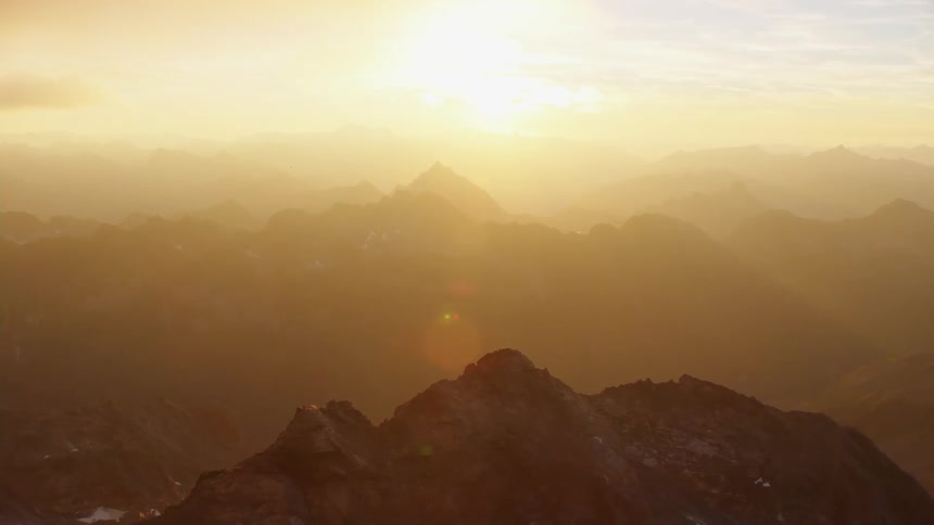 Aerial view of mountain ranges as the sun shines brightly