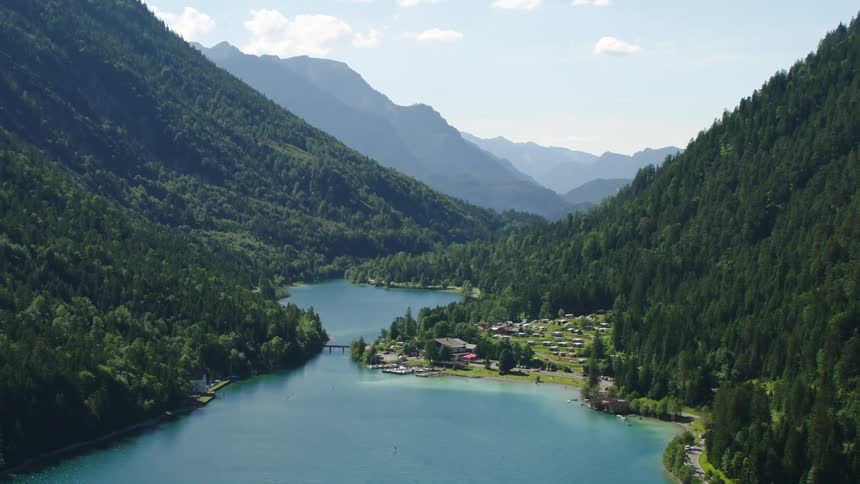 Aerial view of town between river and mountain with forest