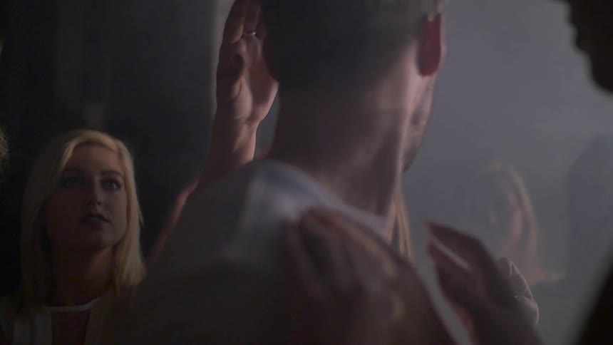 A man is being touched by many women at once