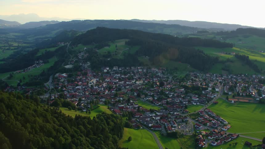 Aerial view of a small town nested on a valley between mountains at morning