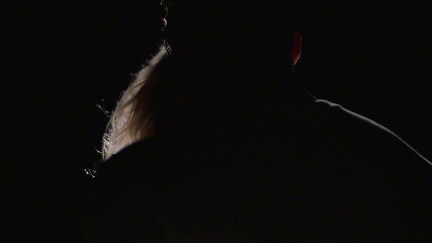 A woman smiles as she moves close to a man