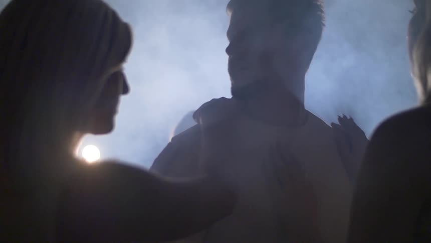 A man looks around as women touch him from all sides