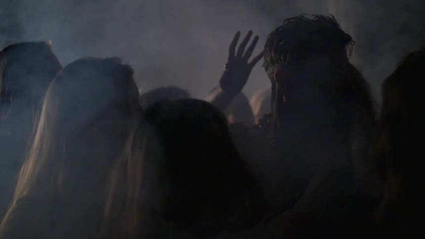 A man walks through a large group of women