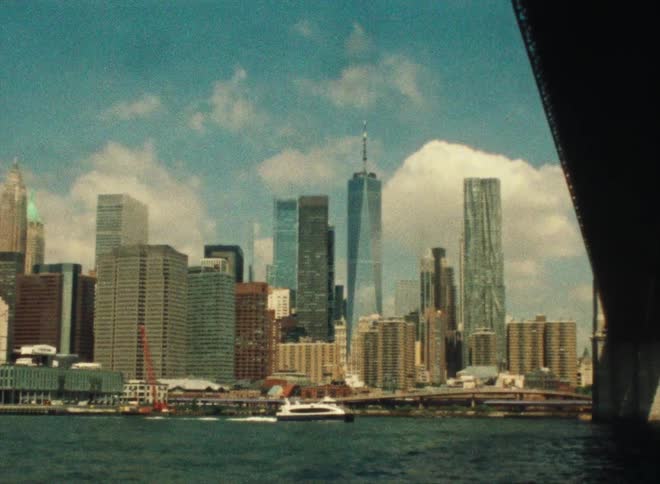 The new york skyline from under the brooklyn bridge with the freedom tower standing tall