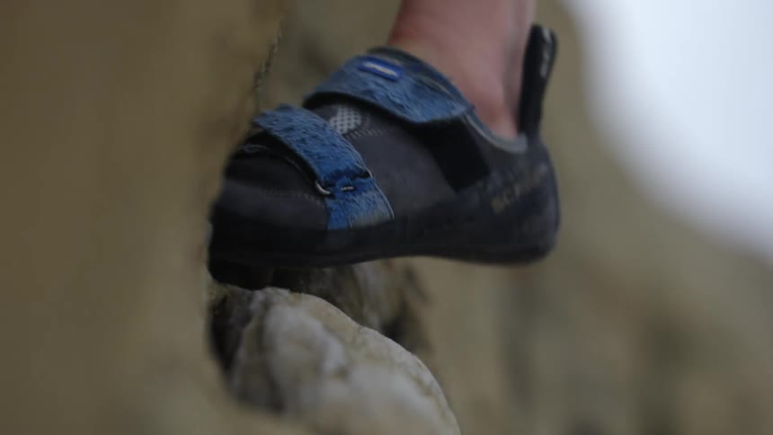 A rock climbers foot balanced on a cliffside
