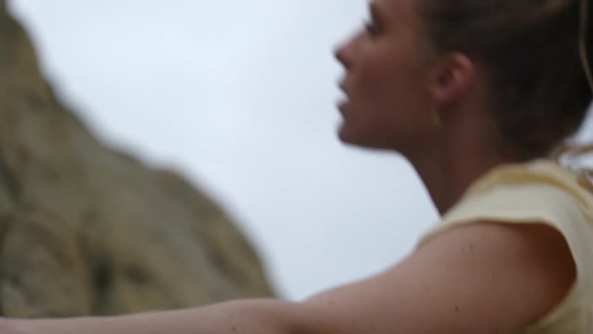 Female climber climbs rock of cliff side