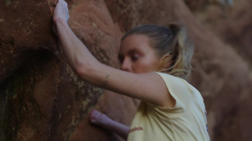 Woman free climbs rock wall in the outdoors