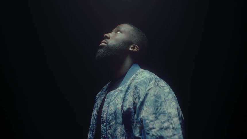 Black man stand in the dark and looks up