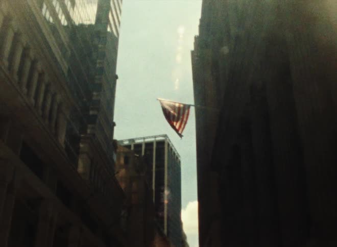 American flag hangs from a pole that is attached to the side of a building