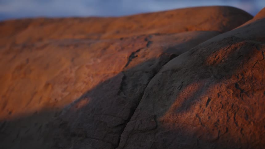 Shadow of a thin woman cast over a rock at evening