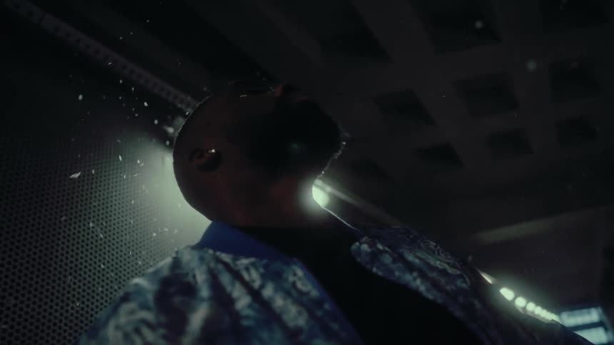 A man holds his head back as water splashes around him in a tunnel