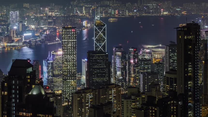 Boats sail through the sea along a downtown city