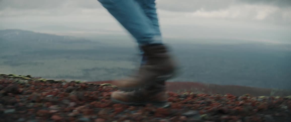 A person is walking along a mountain ridge