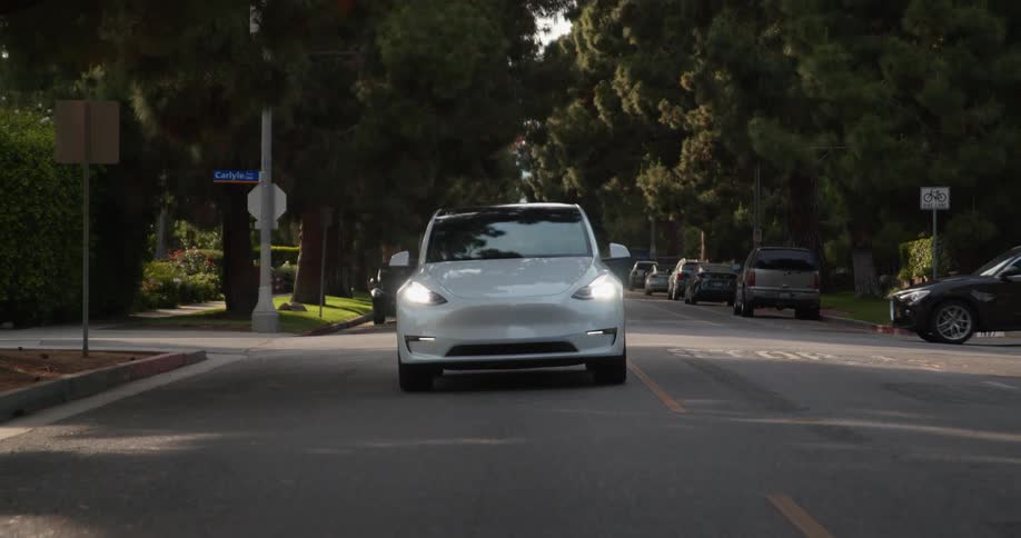 A vehicle stops and passes through an intersection in a neighborhood