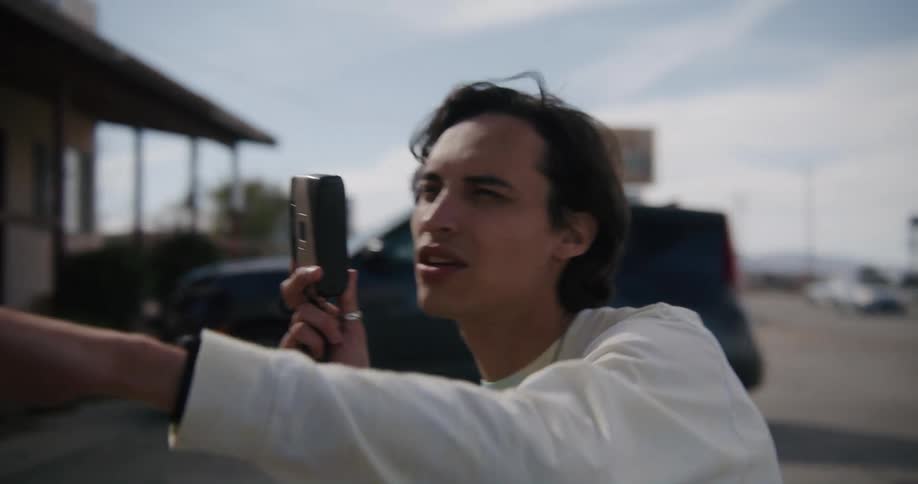 A man talks and points a camera