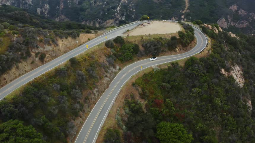 A car is driving on the road on the mountain