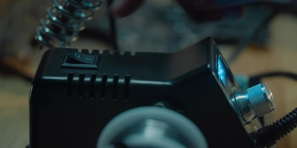 A person turning off a soldering iron