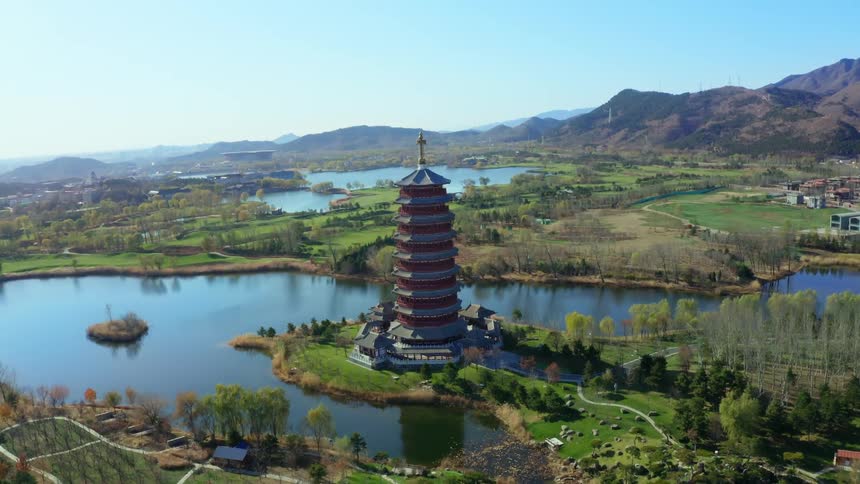 A drone shot approaching a tall round pagoda-style building in Yanqi Lake, north of Beijing, China