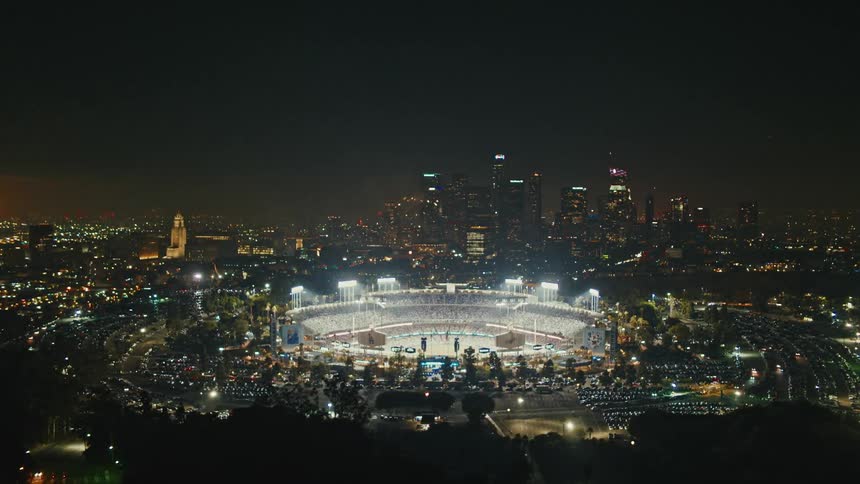 A stadium in a city is lit up with fireworks going off