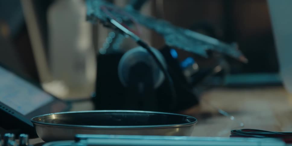 A man pours liquid from a jug into a bowl next to tools