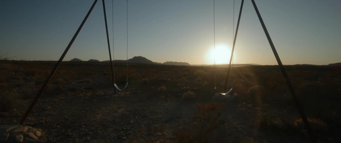 A swing set in an arid grassland during the day
