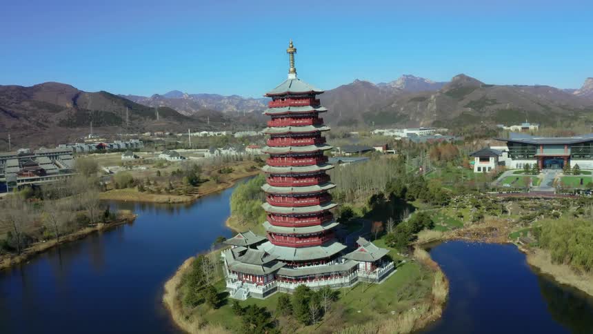 A drone shot orbiting a tall round pagoda-style building in Yanqi Lake, north of Beijing, China