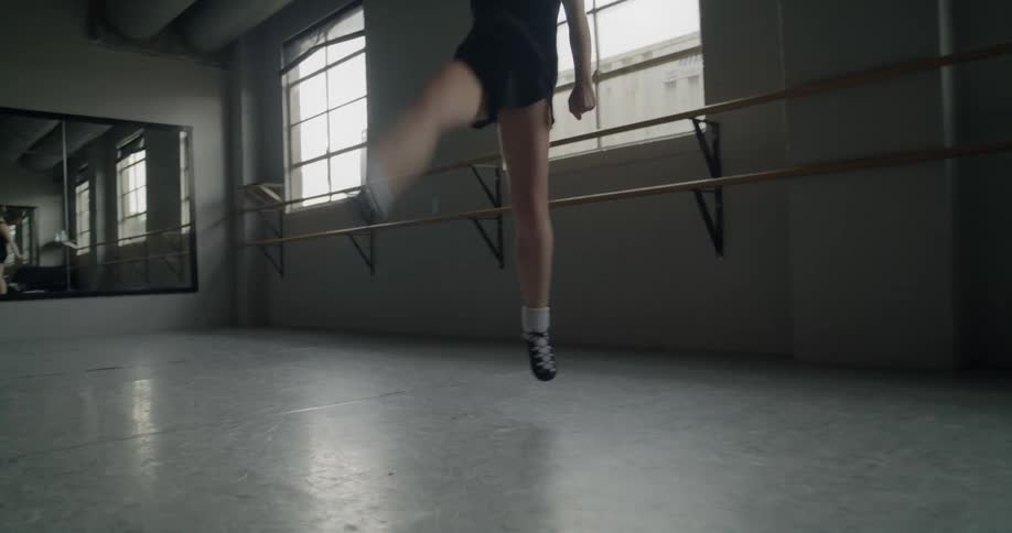A girl is doing ballet in an empty room