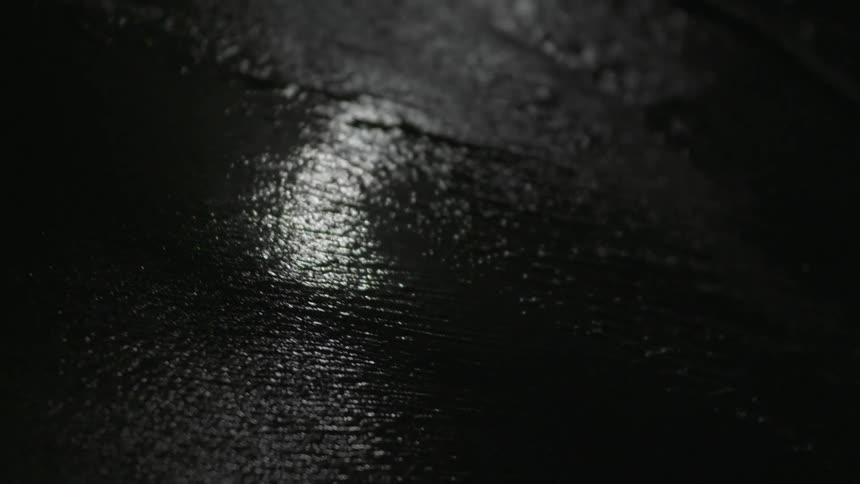Water laps against sand on a beach lit by moonlight in Tulum, Mexico