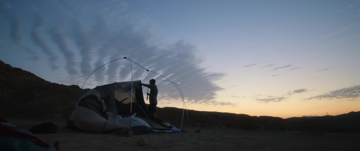 A view of a person taking down a tent