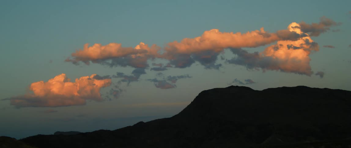 The sun is setting in the horizon of a landscape