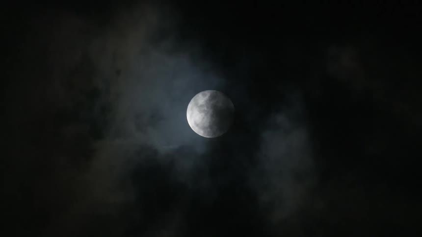 A full moon is revealed by clouds in Tulum, Mexico
